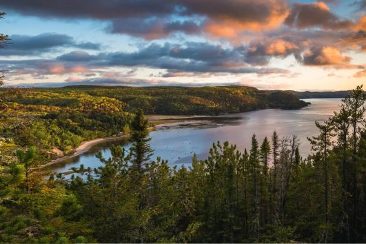 This image shows a scenic cycling tour on a quiet paved road in the Saguenay region of Quebec
