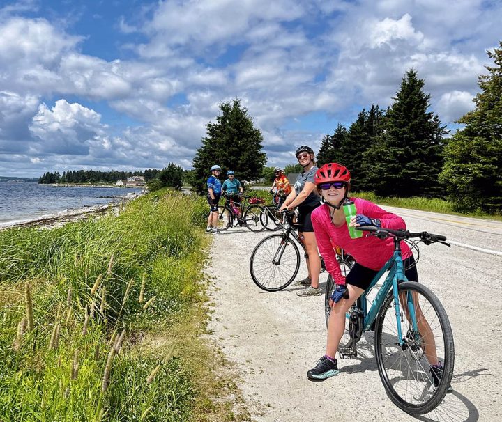 This image shows a group of cyclists enjoying a ride on a scenic trail on the south shore of Nova Scotia