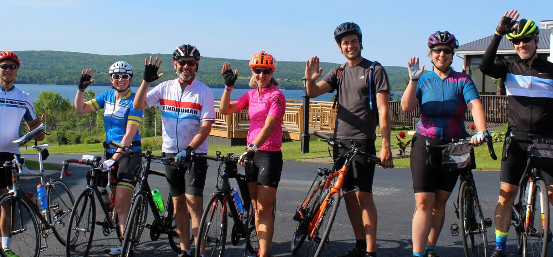 A growing group of waving cyclists