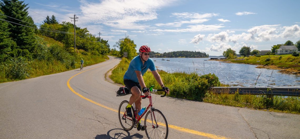 Cyclist beside the ocean on Nova Scotia's South Shore Bike Tour