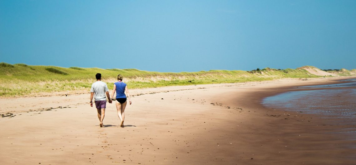 Couple walking on a beach on tour with Freewheeling Adventures