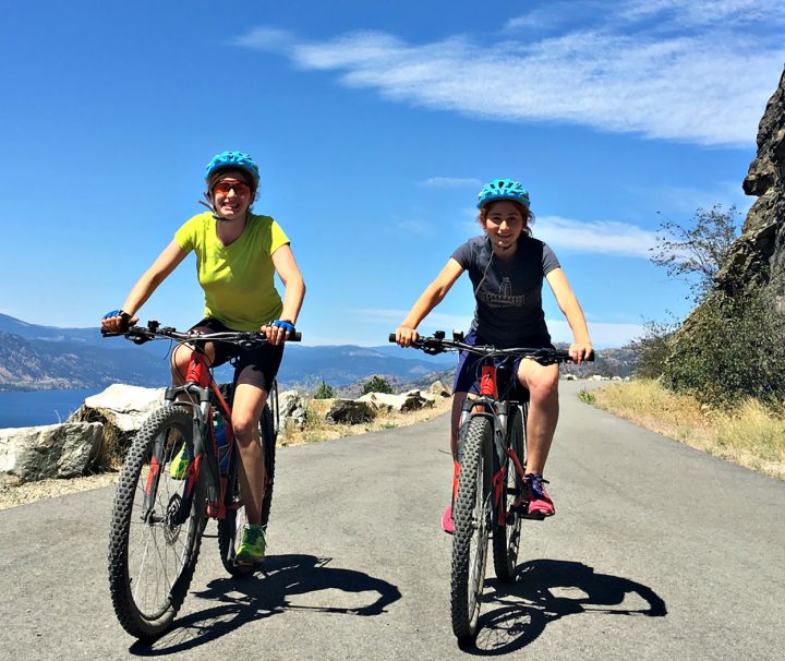 3 happy cyclists on a traffic free cycling path with Freewheeling Adventures in the Okanagan Valley of British Columbia.