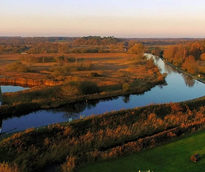 This image depicts a serene moment in The Broads National Park, a vast network of navigable waterways and wetlands in England