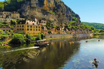 This image shows the scenic village of La Roque-Gageac situated along the Dordogne River in southwestern France