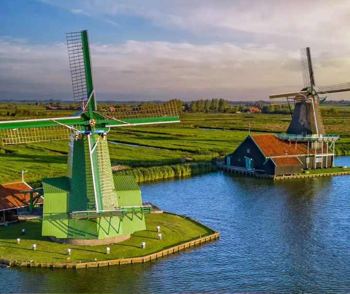 The image features the iconic Zaanse Schans windmills located in the Netherlands