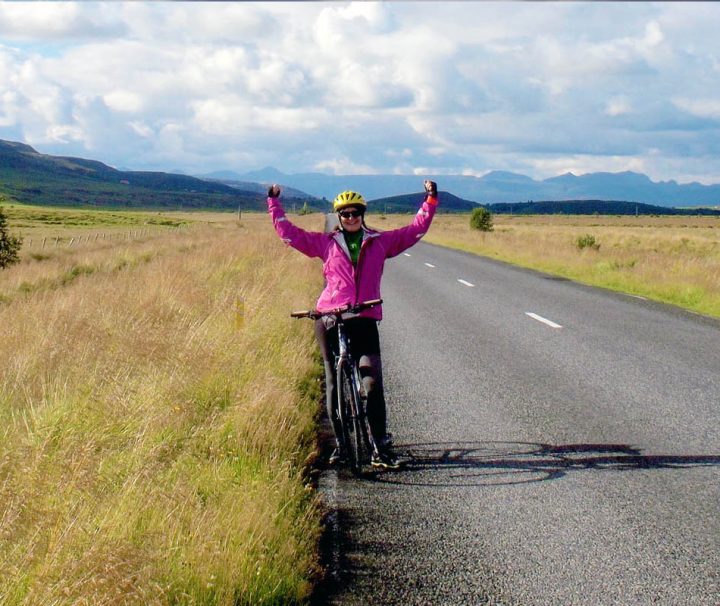 This image captures a cyclist pausing for a photo on a scenic road in Southern Iceland